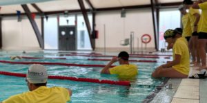 Grupo de estudiantes practicando técnicas de rescate acuático en la piscina durante el curso de socorrismo en Montoro