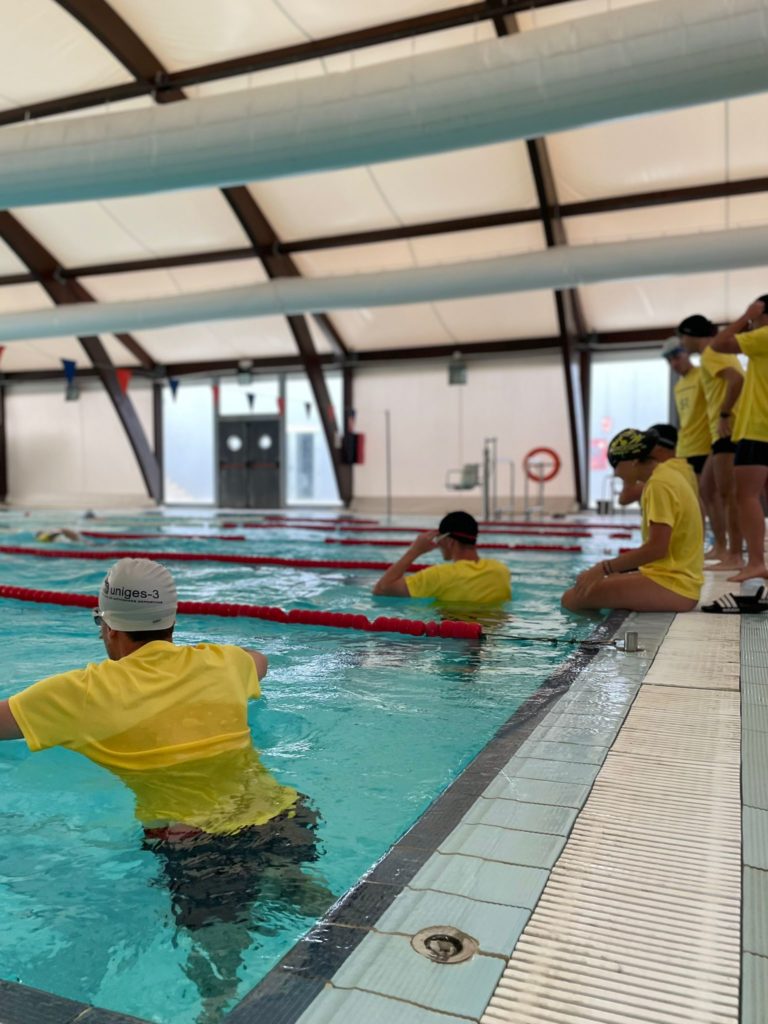Grupo de estudiantes practicando técnicas de rescate acuático en la piscina durante el curso de socorrismo en Montoro
