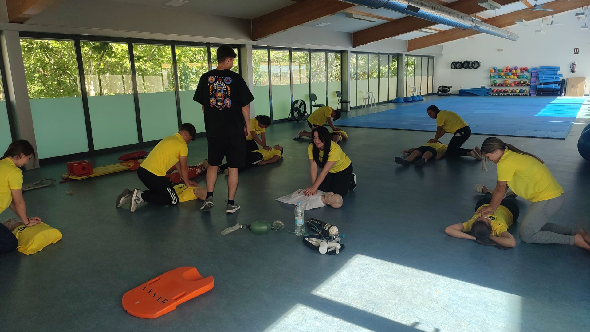 Grupo de alumnos en una sala practicando técnicas de Reanimación Cardiopulmonar (RCP)